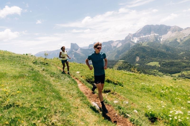 Deux coureurs progressent sur un sentier alpin en forte montée
